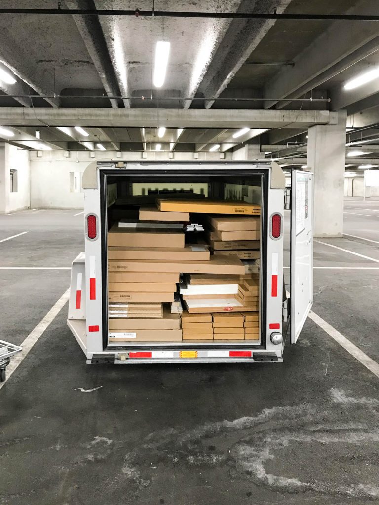 A picture of a u-haul trailer filled with cabinet boxes in the Ikea parking lot.
