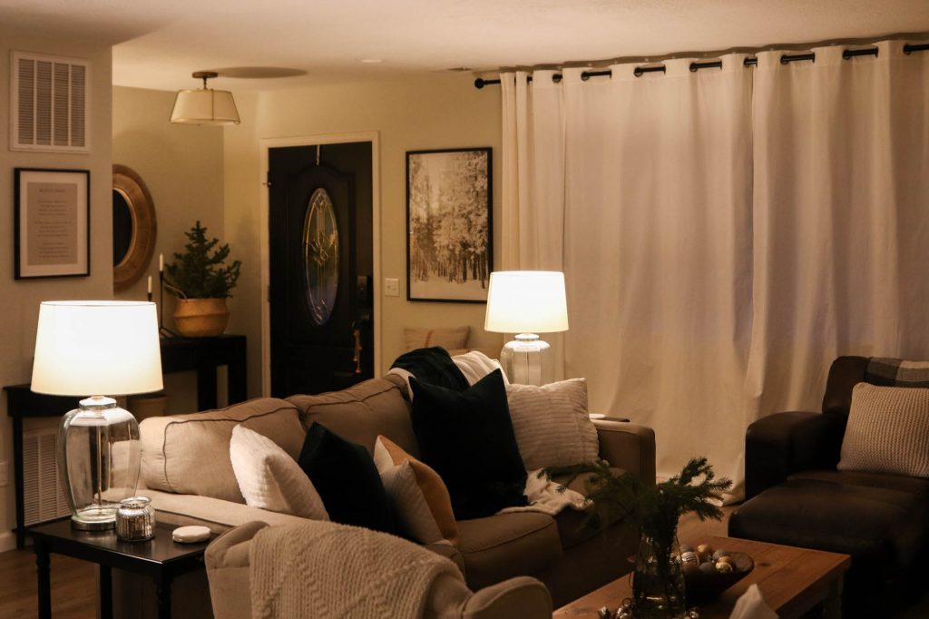 A picture of a living room with lamp lights on. 