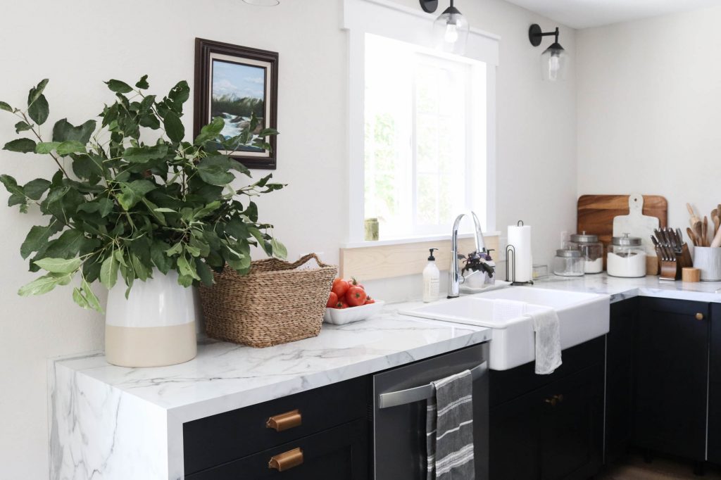 A picture of a kitchen with black cabinets.