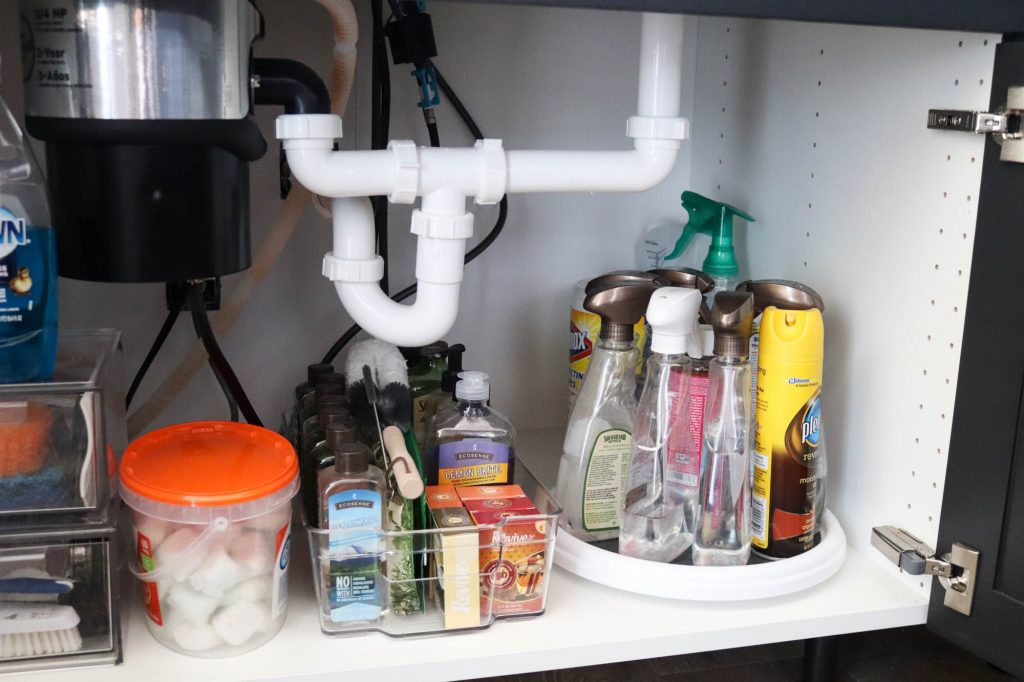 A picture showing the third step of organizing under the kitchen sink: putting things back under the sink.