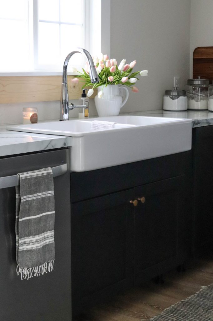 A picture of the kitchen sink and the cabinet underneath it. 