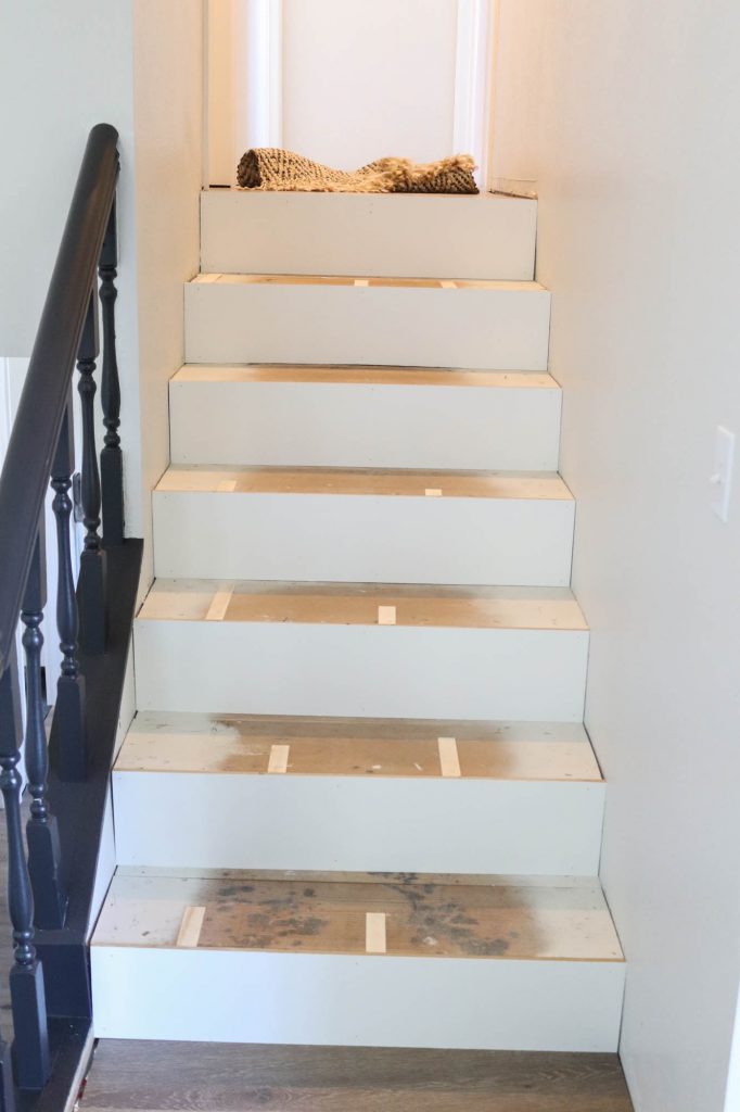 A picture of the stairs with shims nailed in place.