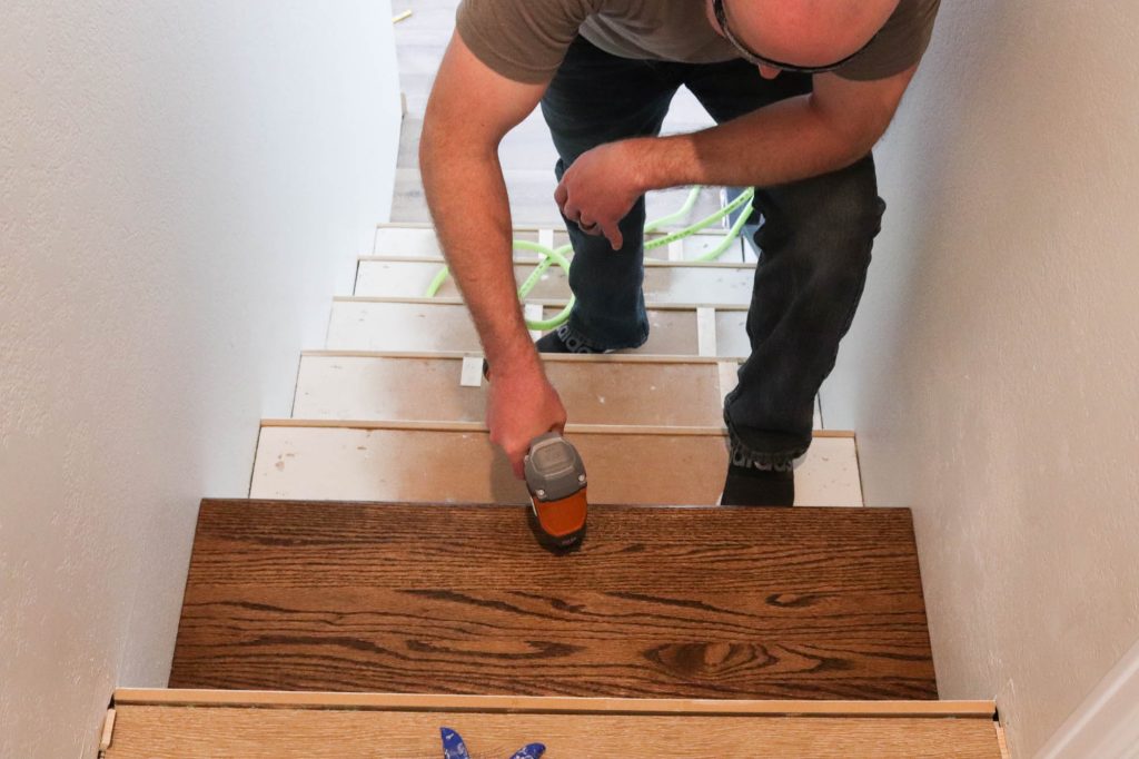 A picture of Todd nailing in the new stair tread. 