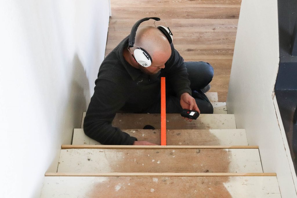 A picture of Todd working his way down the stairs with the new risers. 