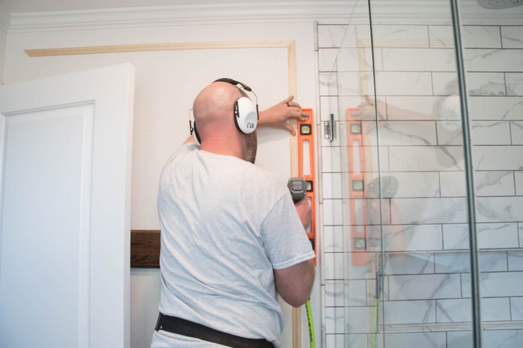 A picture of Todd leveling and installing the top vertical pieces.