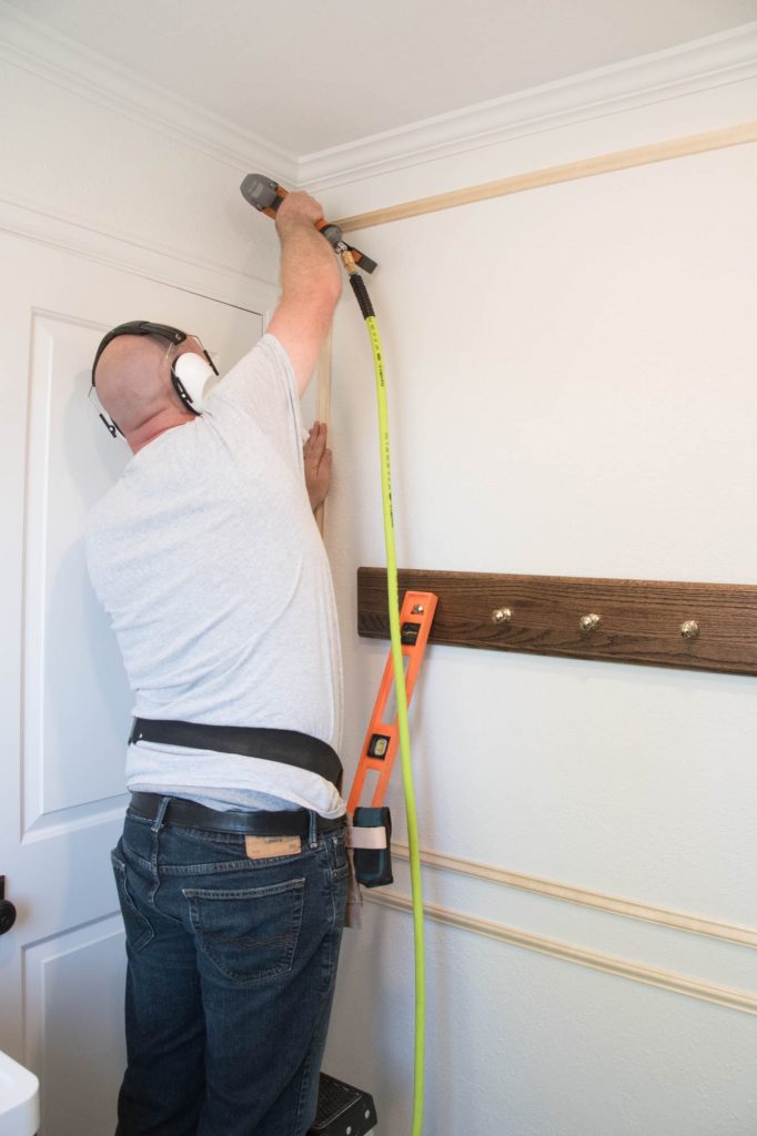 A picture of Todd nailing in the vertical moulding pieces.