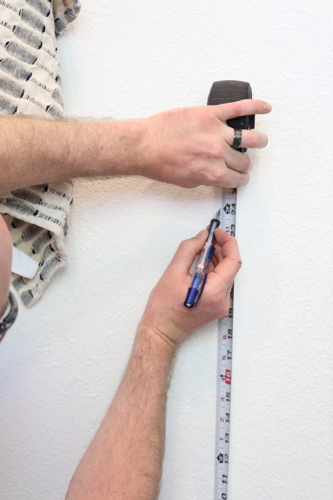A picture of Todd measuring the wall. 