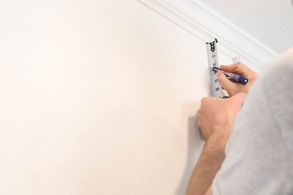 A picture of Todd measuring the wall. 