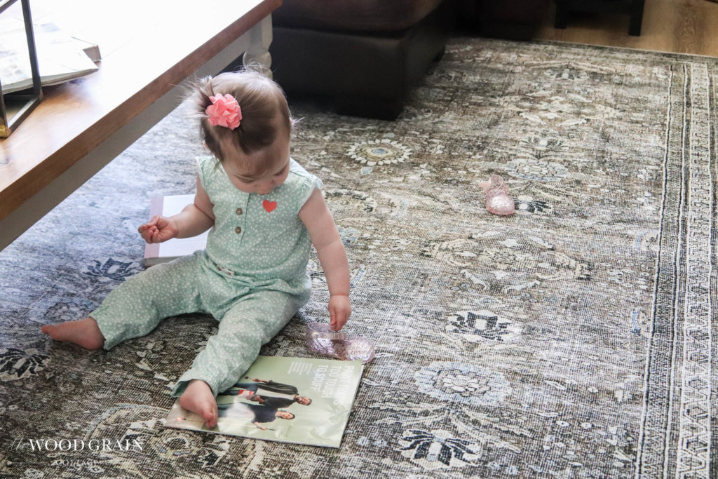 A picture of Ania sitting on the new living room rug. 