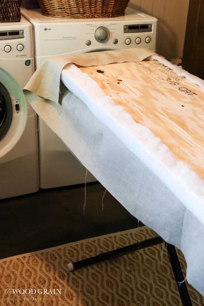 A picture of the fabric being stapled to the board. 