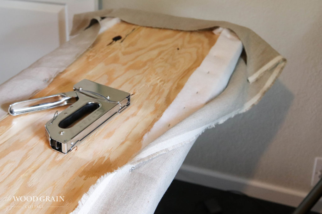A picture of the fabric being stapled to the board.