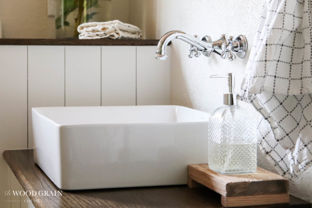 A picture of the vessel sink and wall faucet. 